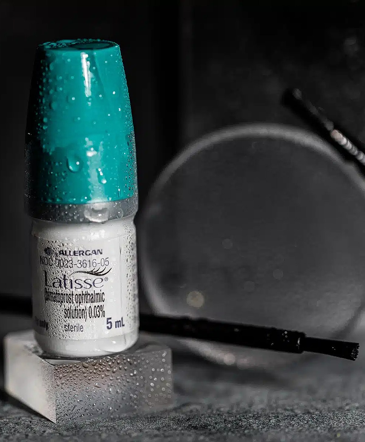 Bottled eye drop solution on a reflective surface.