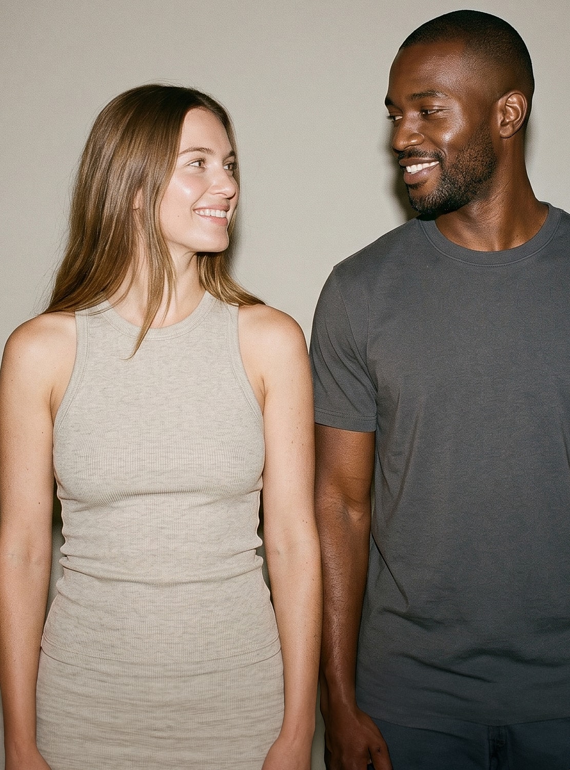 Diverse models smiling in casual attire together.