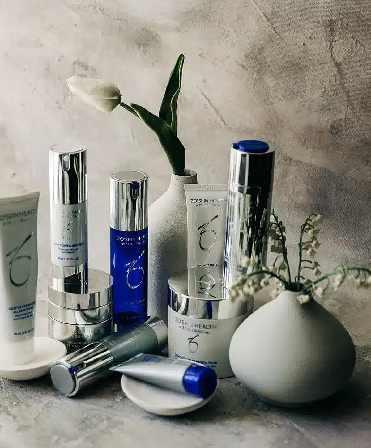 Skincare products arranged artistically with flowers.