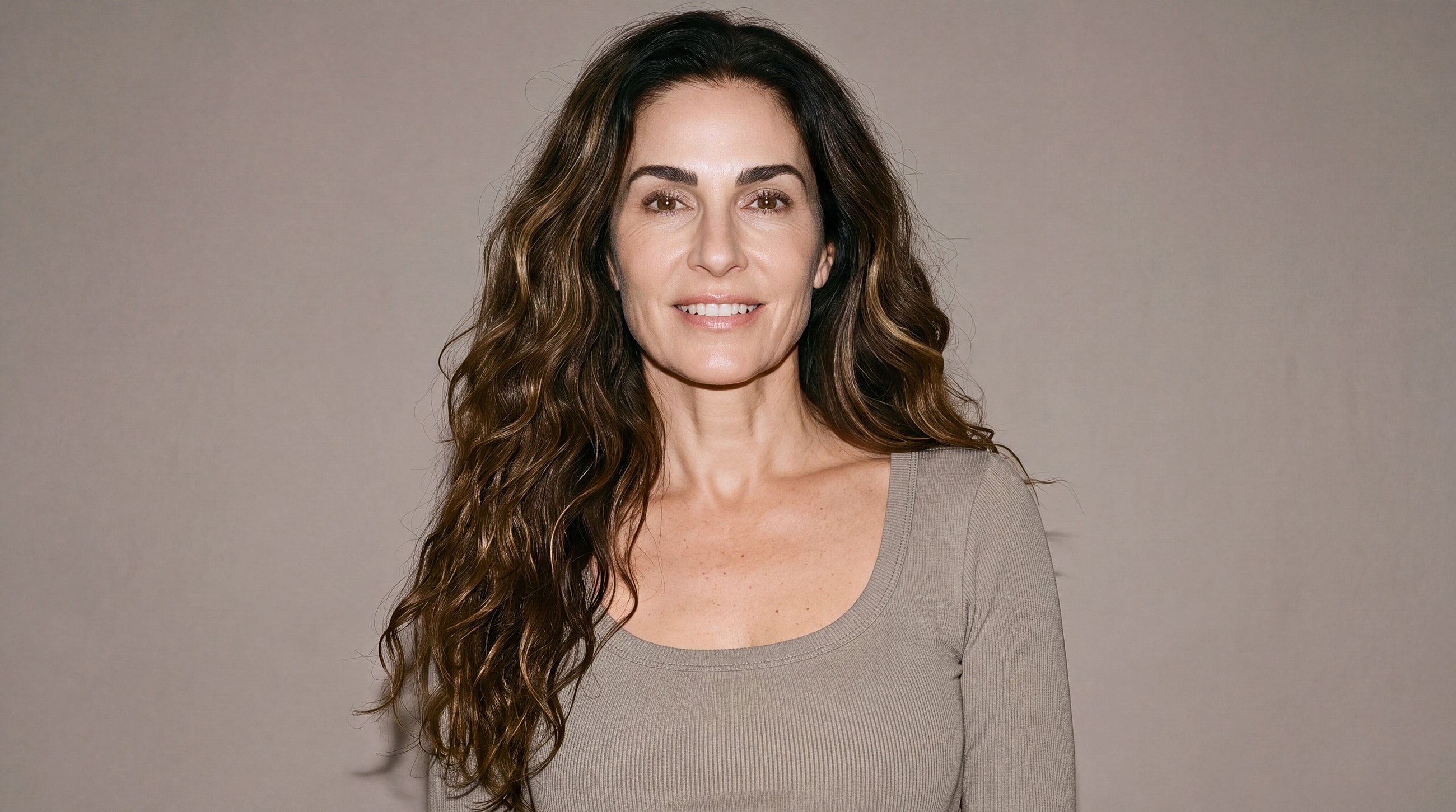 Smiling woman with long, wavy hair.